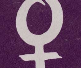A badge with a purple background bearing the female symbol.