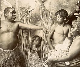 Staged portrait of an Aboriginal Australian family dressed in tradtional attire.