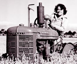 Photograph of a woman driving a tractor during World War II.